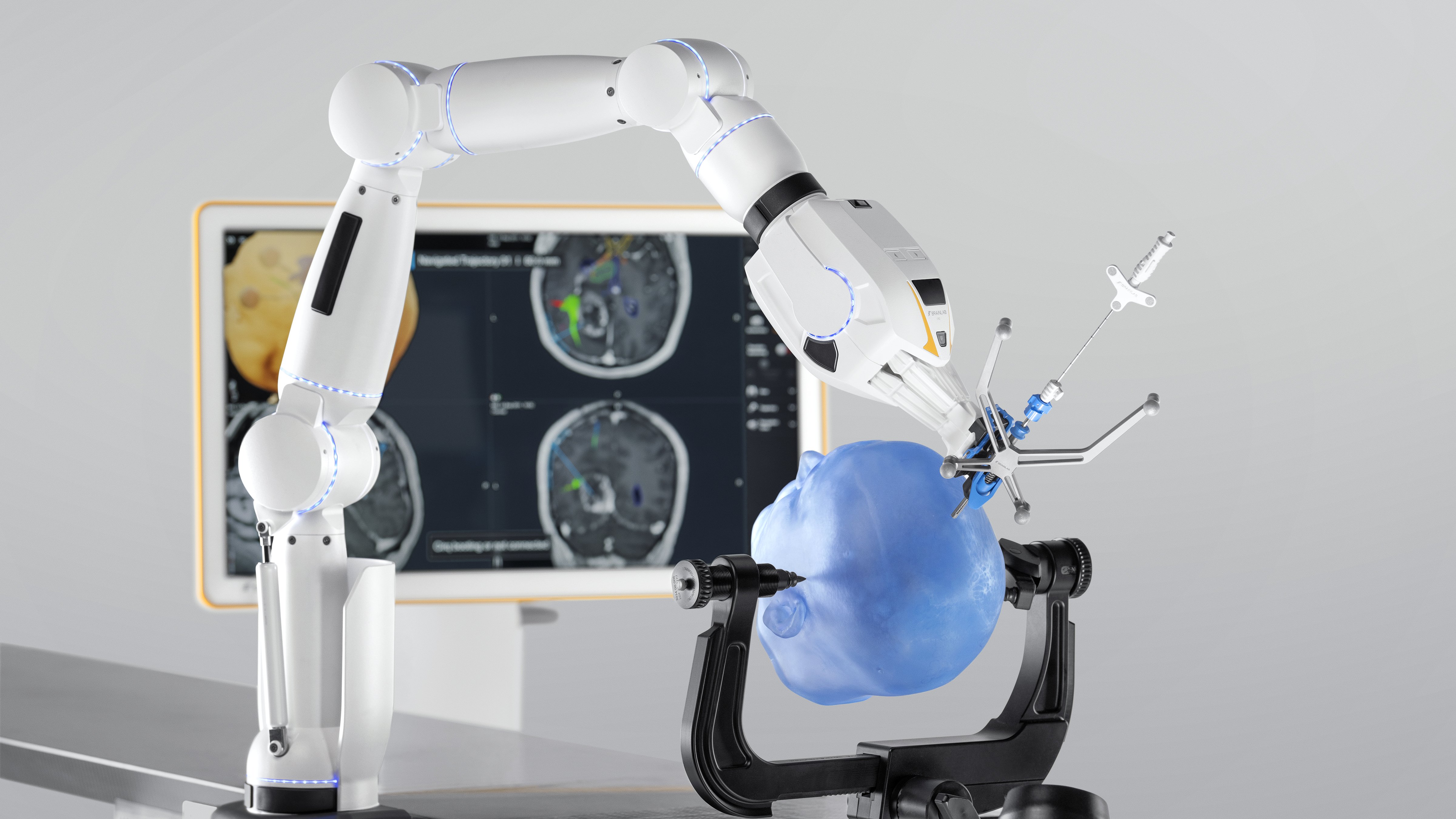 Cirq Cranial Biopsies: Table-mounted Cirq Cranial system with monitor displaying software, accompanied by a phantom patient