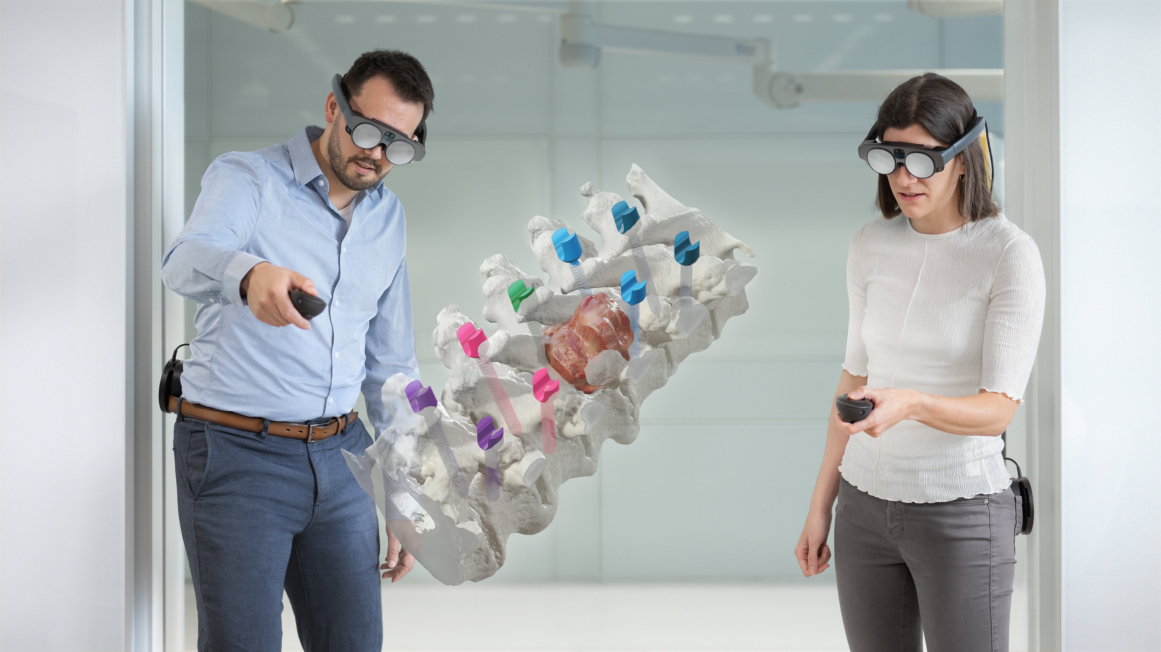 Brainlab's Mixed Reality Viewer in action, with two individuals in an office setting viewing a spinal image