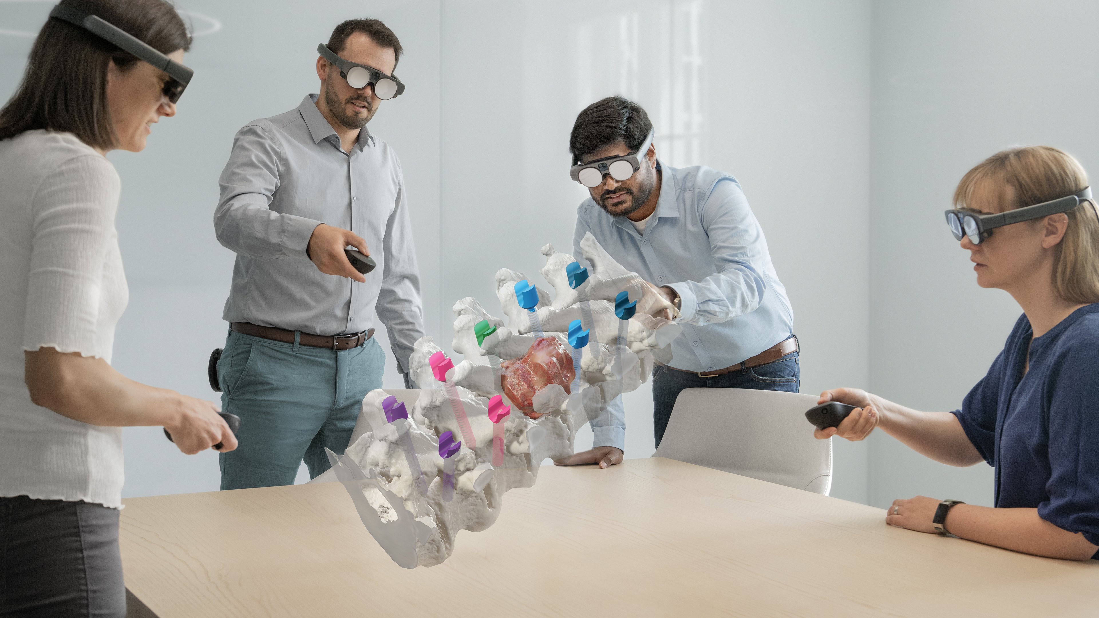 Brainlab's Mixed Reality Viewer in use, with four individuals in an office setting examining a spinal image
